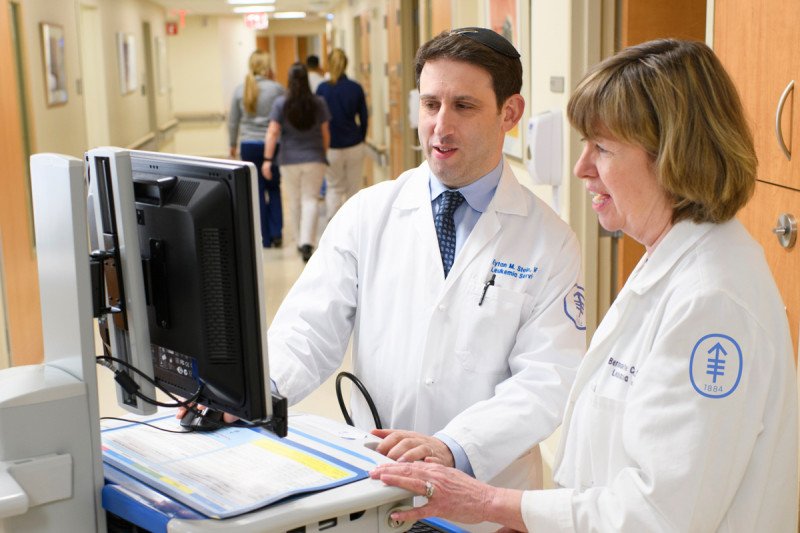 Eytan Stein at a computer with nurse practitioner Bernadette Cuello