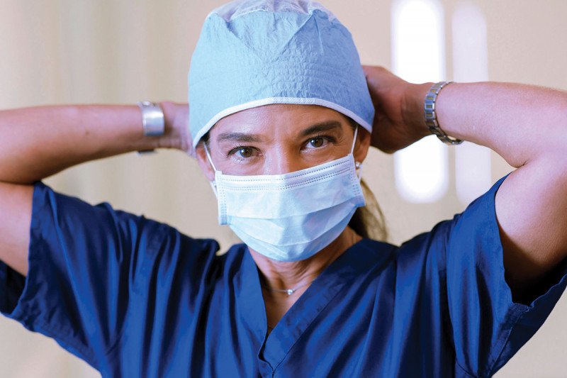 Gynecologic surgeon Carol Brown tying on a surgical cap