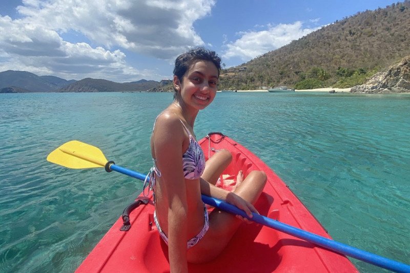 Sona on a kayak, looking over her shoulder at the camera
