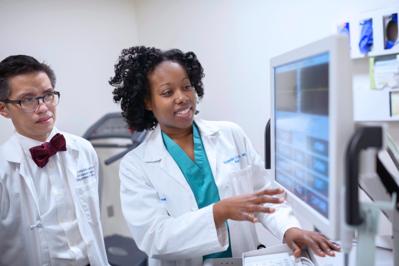 Two doctors look at a computer screen