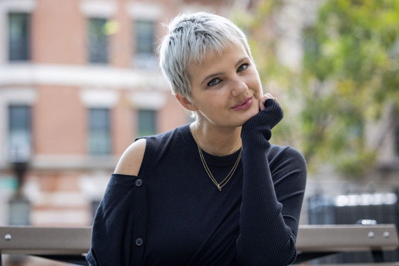 Young woman with short hair poses for photo