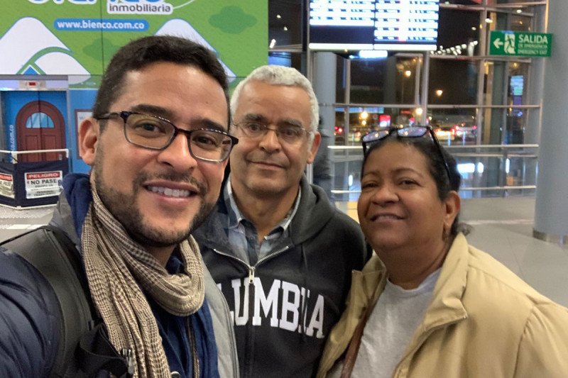 Cesar Figueroa Ortiz posing for a photo with his parents