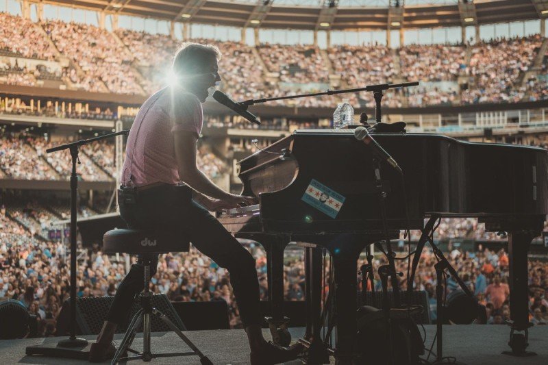 Andrew McMahon performs on stage in front of a crowd.