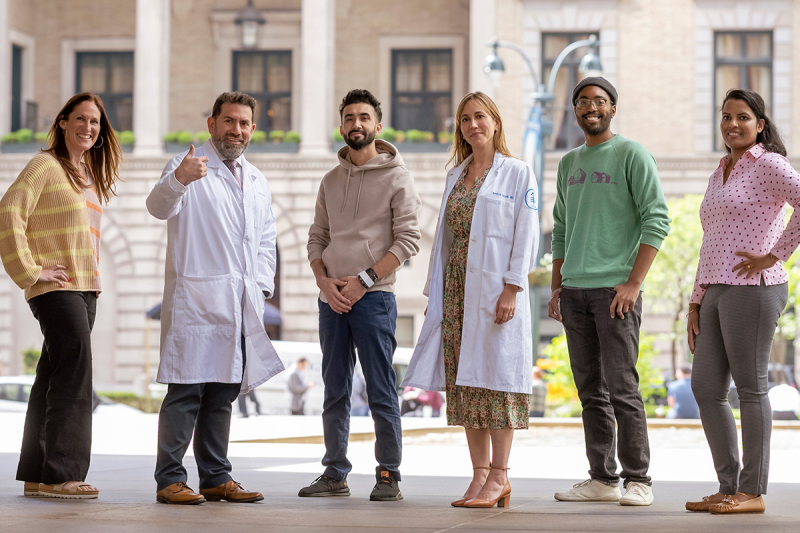Four people treated for rectal cancer in a clinical trial at MSK are seen outdoors with the trial’s two principal investigators. 