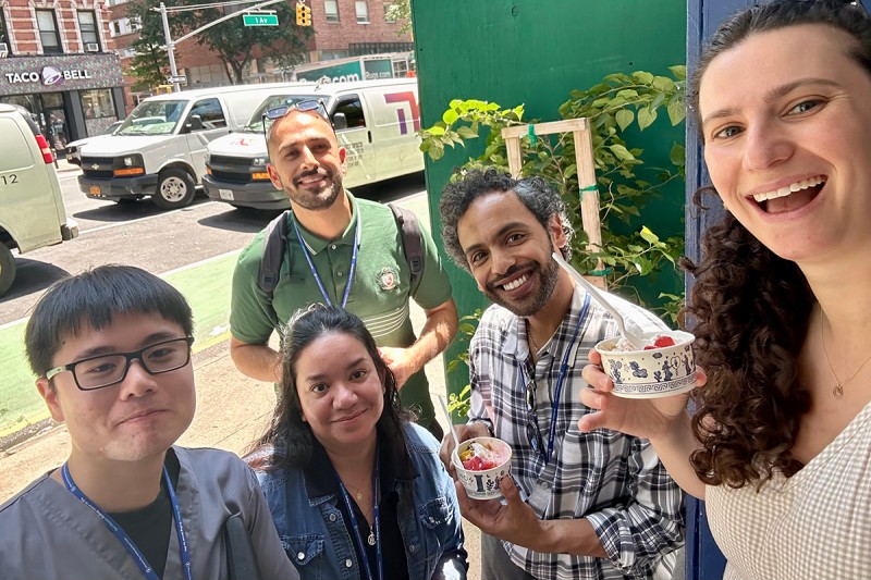 Fellows enjoying Greek yogurt together outdoors on a hot summer day.