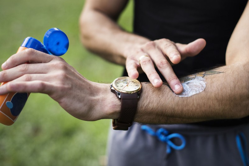 Man putting on sunscreen