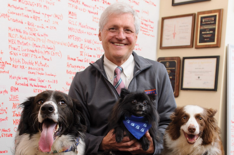 Medical oncologist Mark Kris takes a breather with (from left) Clinton, Satchmo, and Kelly.