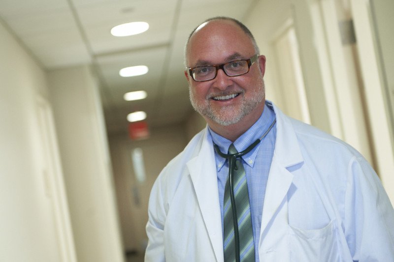 MSK medical oncologists, David Ilson, smiles at the camera dressed in a white lab coat 