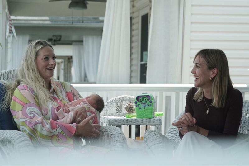 Kelly Spill is seen outdoors holding her newborn and talking with Dr. Andrea Cercek of Memorial Sloan Kettering Cancer Center.