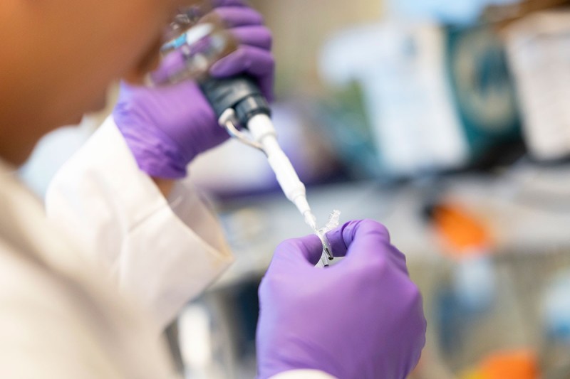 Close up of gloved hands working in a lab