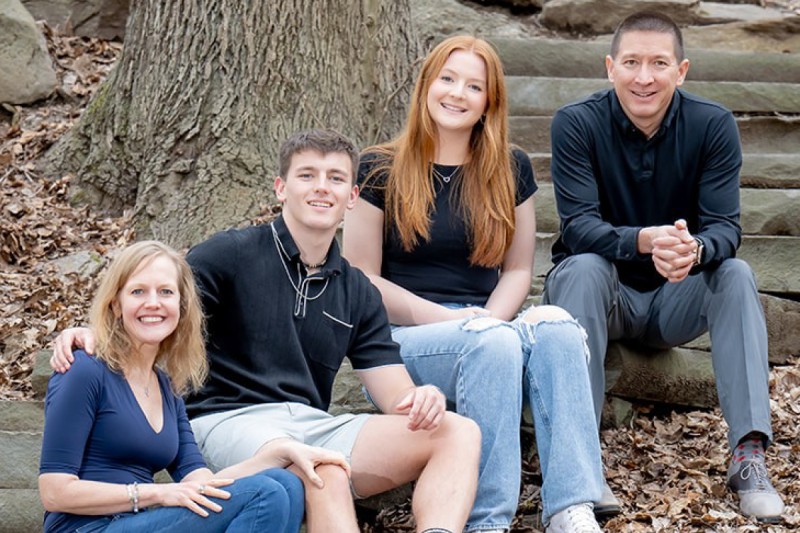 Family of four sitting and smiling for camera.