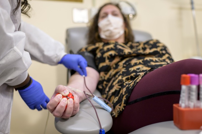 A person reclining in a chair donates blood
