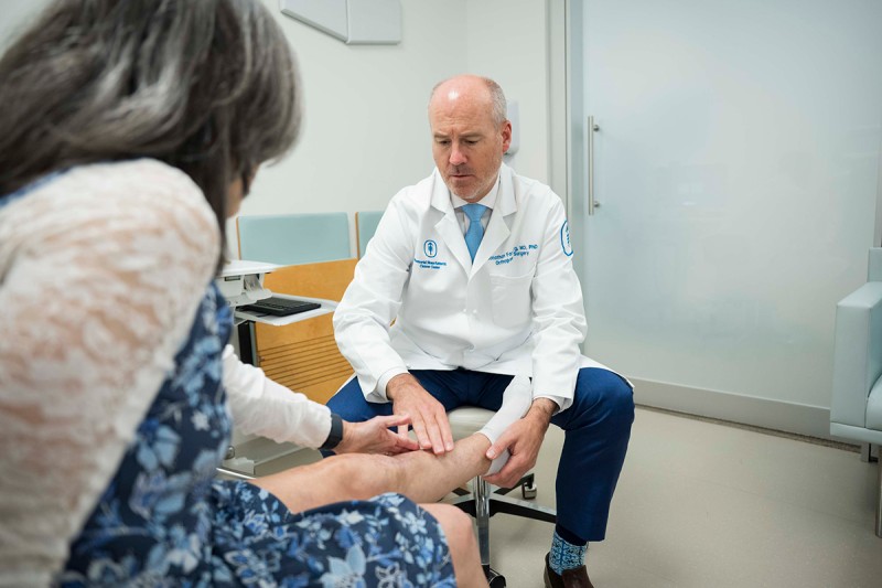 MSK orthopedic surgeon Dr. Jonathan Forsberg examines a patient's leg 