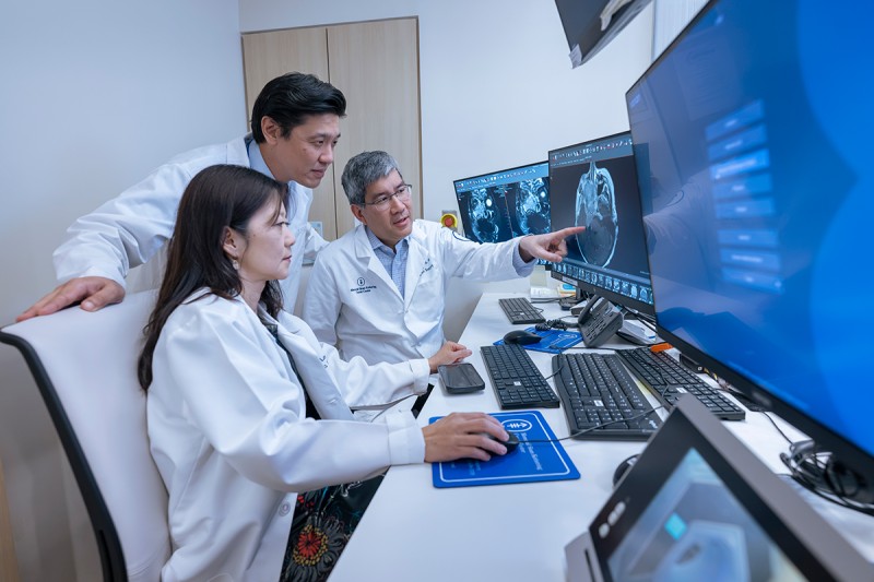Doctors Nancy Lee, Alan Ho and Richard Wong are seen discussing a medical image. 