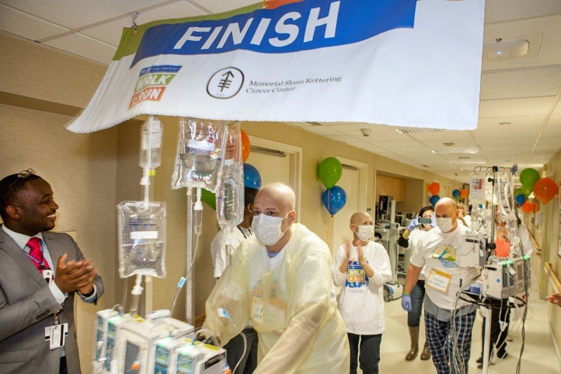 (From left) MSK patients Adam Lopranos, Eileen Grimes, and Jeffrey Scarpitti cross the finish line after walking the halls to support marrow transplantation.