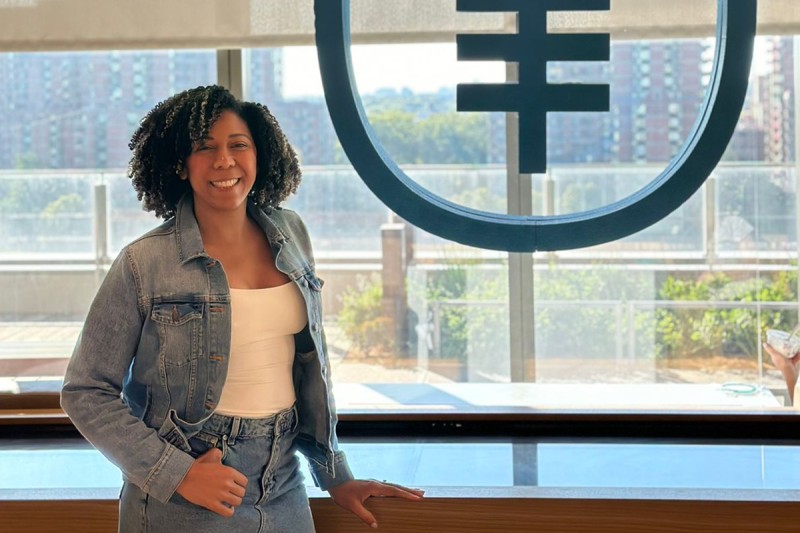 Reicy Bobadilla stands in front of a window with the MSK logo on it