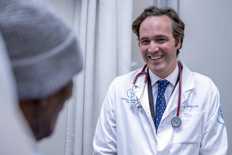 Dr. Bobby Daly seen smiling with patient. 