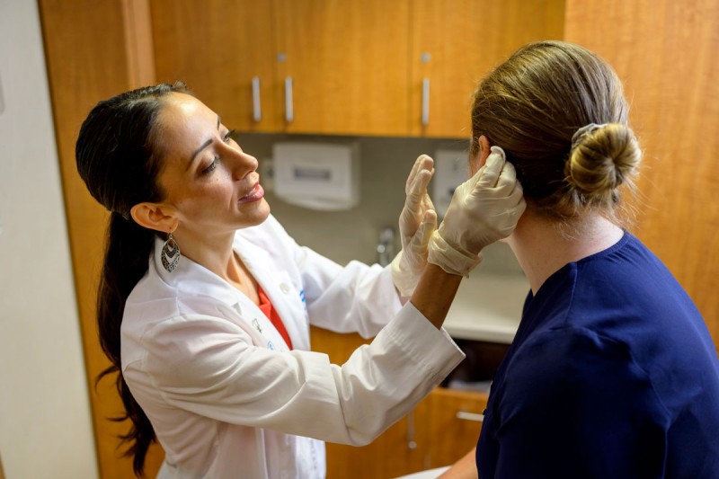 Clinical Nurse II Adelita Hinojosa-Martin examines a patient.  