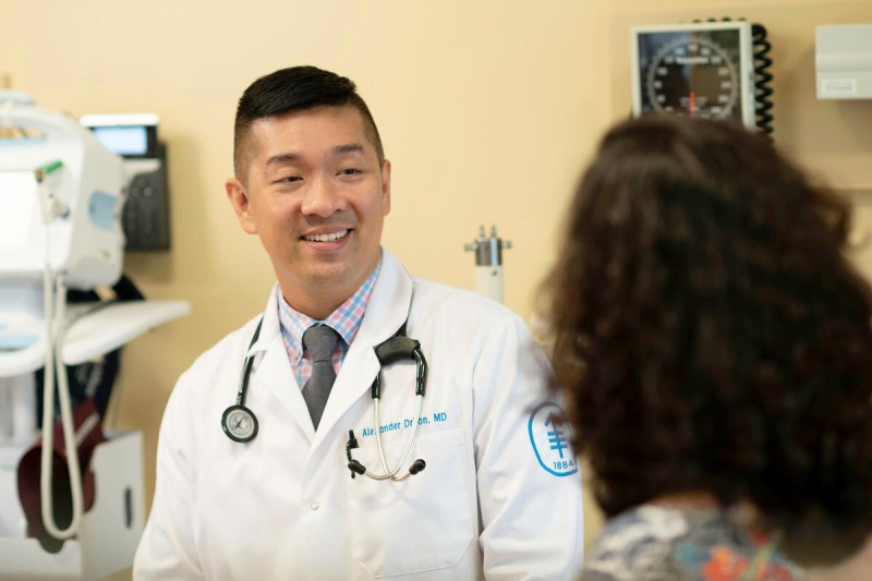 Dr. Alexander Drilon speaks with a patient in an exam room