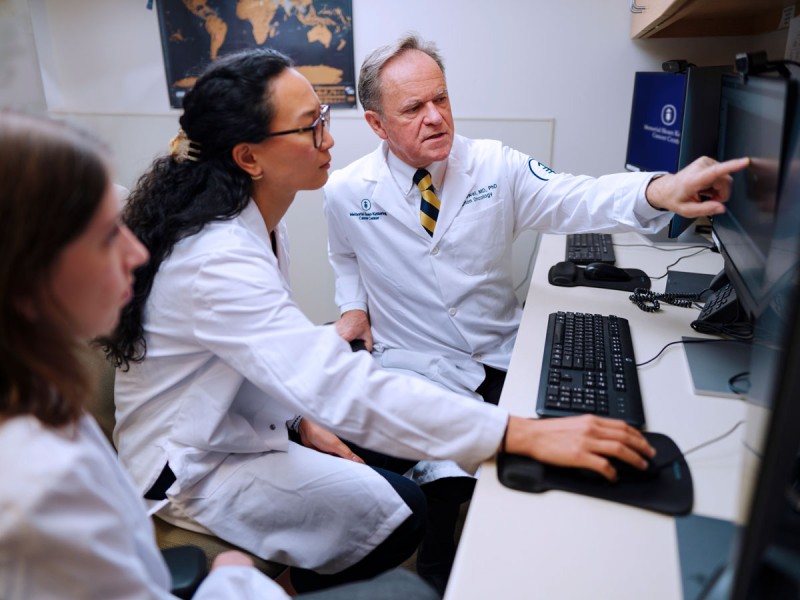 (Left to right) PGY-2 residents Dr. Luiza Giuliani Schmitt and Dr. Boya Wang review cases with Department Chair Dr. Simon Powell.