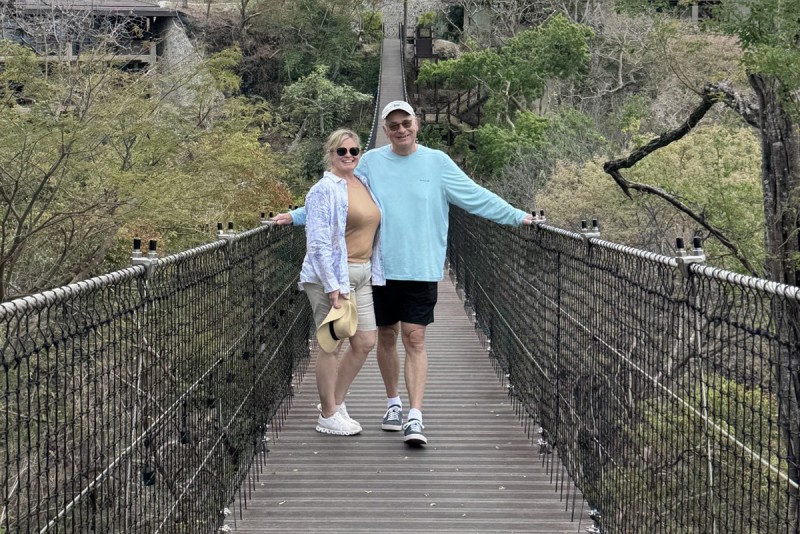 Beth and Mark Ryzyk stand on a long bridge