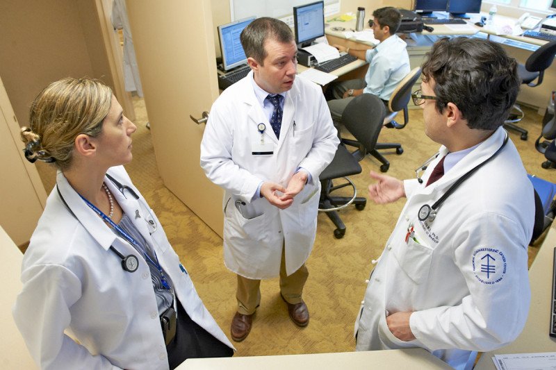 Medical oncologist Gregory Riely and two additional MSK physicians speak in a half circle.