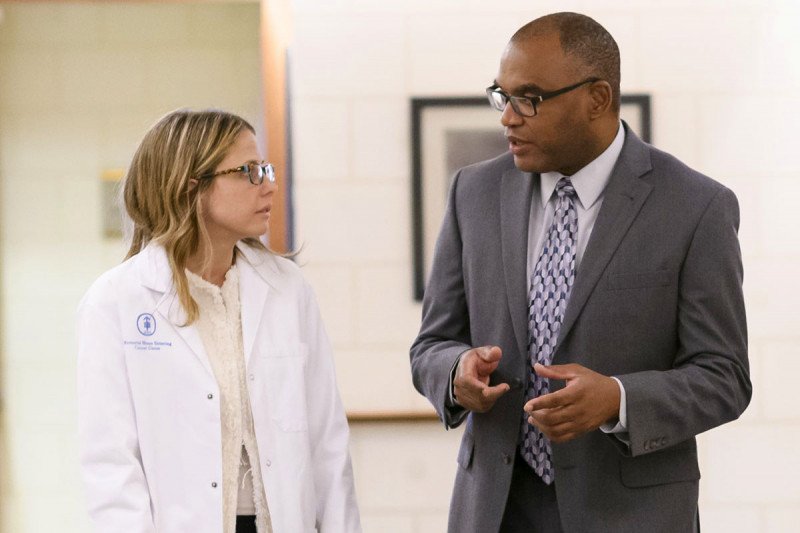 Female doctor in a white coat walking with a male doctor wearing a suit