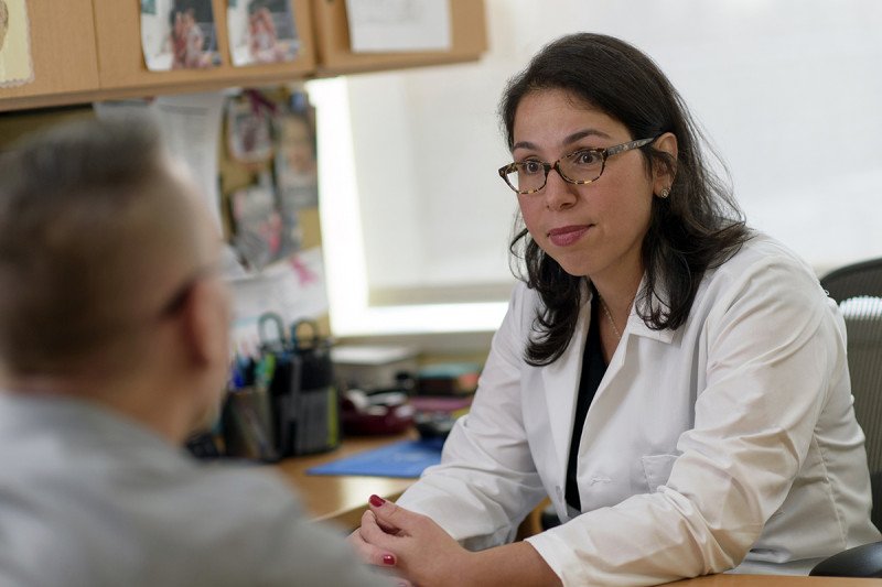 Medical oncologist and male breast cancer expert Ayca Gucalp speaks to male patient in her office.