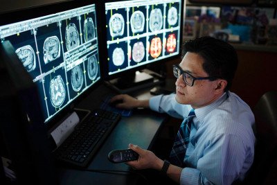 Neuroradiologist Robert Young looks at a computer screen.