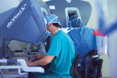 Thoracic surgeon David Finley (center) performs an operation using the da Vinci® surgical robot as surgical fellow Maria Teresa Ruiz Tsukazan (back to camera) learns the procedure.