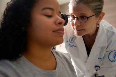 La Dra. Elizabeth Quigley examina todas las áreas de la piel de sus pacientes, incluidas aquellas áreas que reciben poco o nada de sol. El melanoma en piel oscura no está relacionado con la exposición al sol.