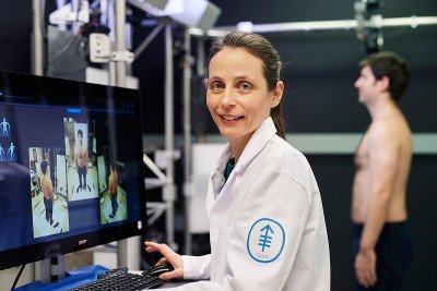 La fotógrafa médica de MSK, Daphne Demas, se para frente a una computadora mientras examina a un paciente para detectar melanoma