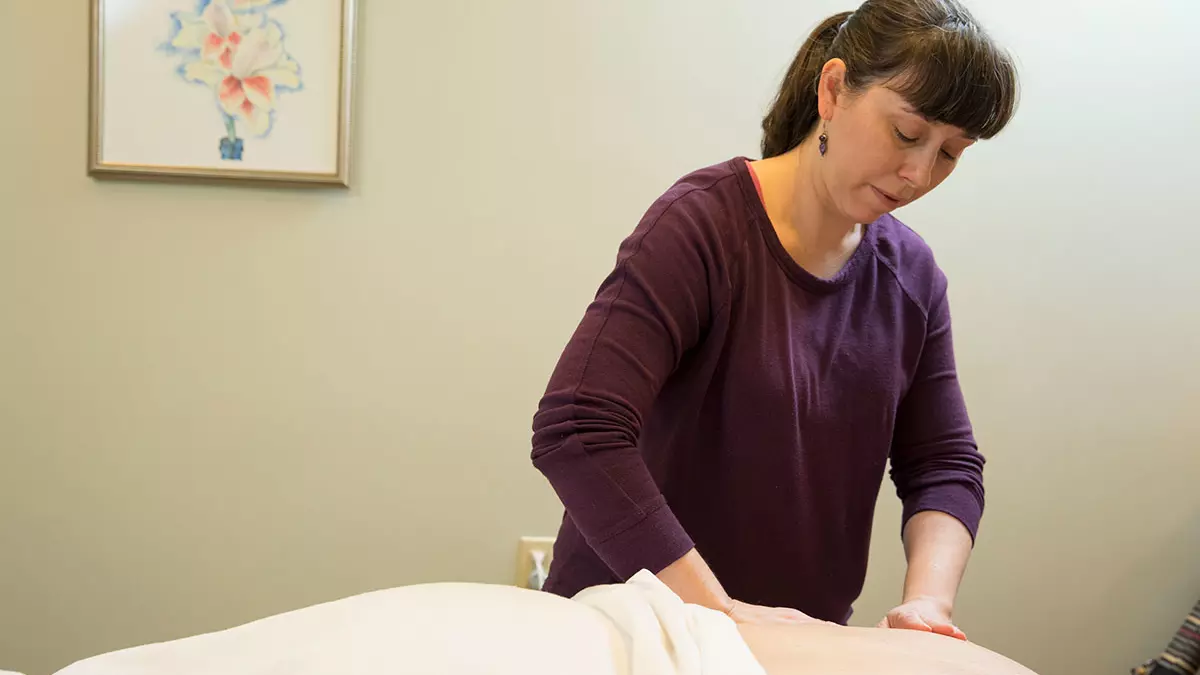 Woman massaging a patient laying on a table