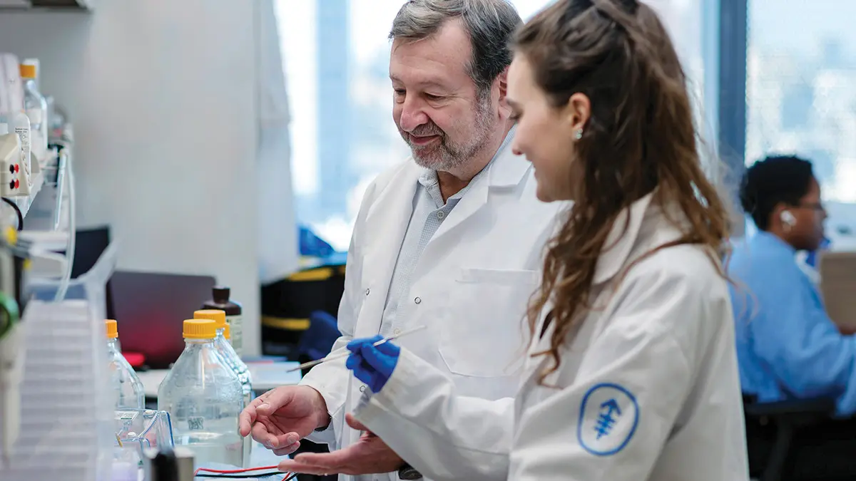 Memorial Sloan Kettering scientist smiling in lab with female assistant.