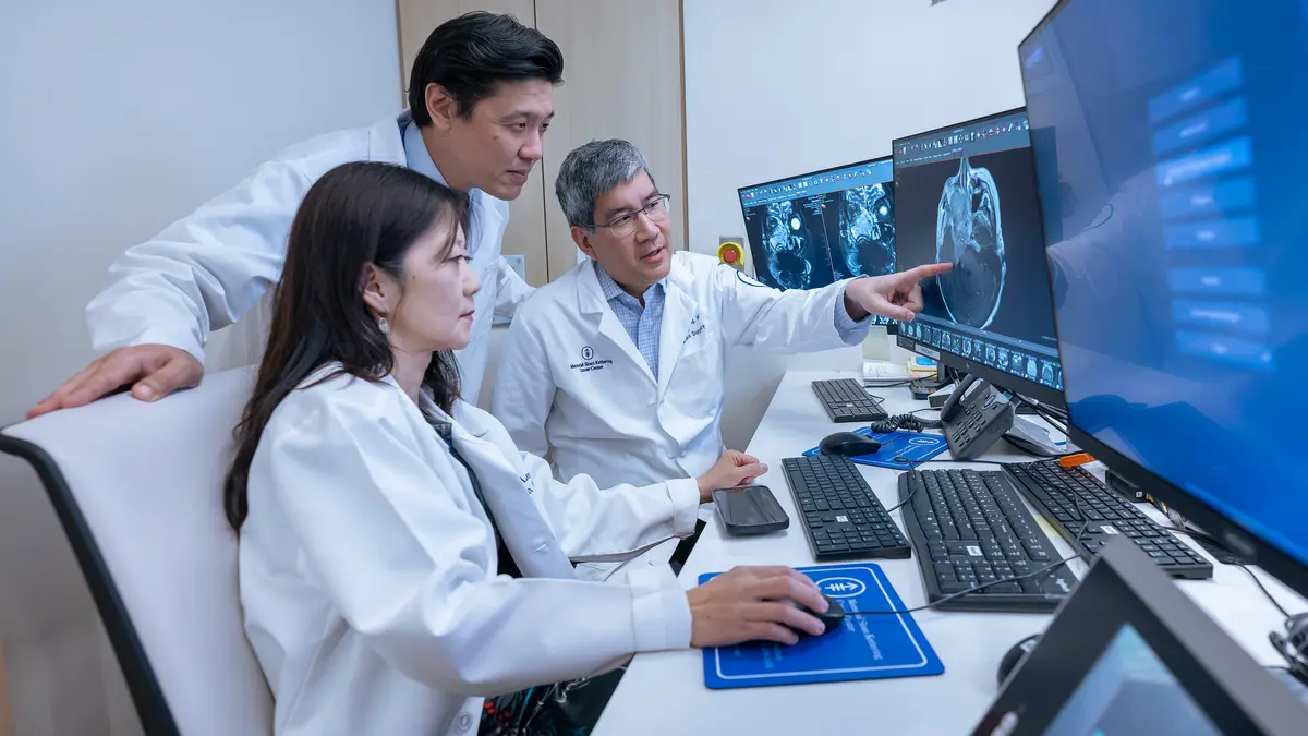 Radiation oncologist Dr. Nancy Lee, medical oncologist Dr. Alan Ho, and surgeon Dr. Richard Wong look at scans on computer monitors. 
