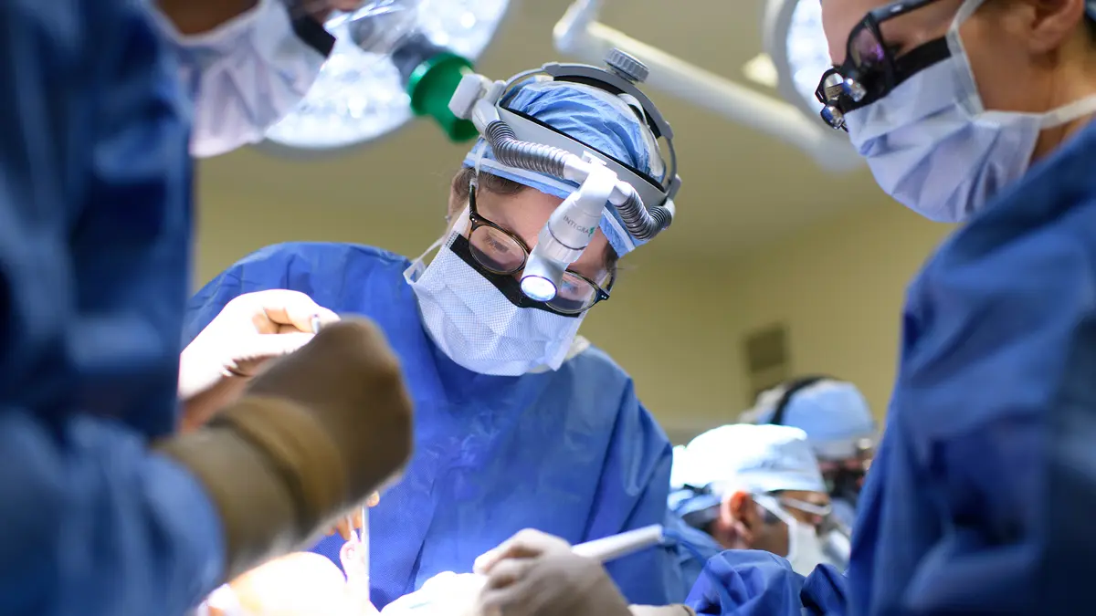 Head and neck surgeon Dr. Jennifer R. Cracchiolo, with 2 other surgeons, during surgery to rebuild a patient’s jaw. 