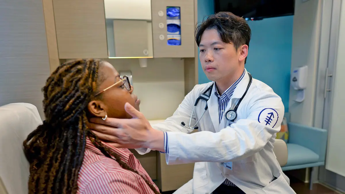 Head and neck medical oncologist Dr. Winston Wong examines the throat of a patient. 