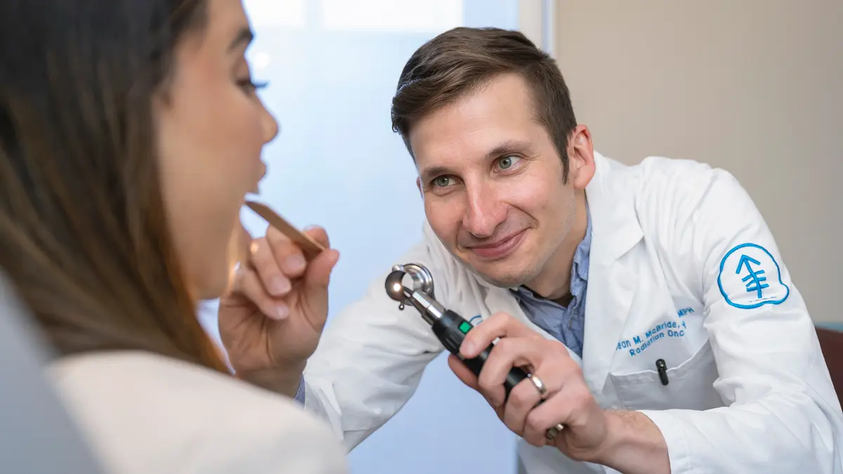 Radiation oncologist Dr. Sean McBride examines the mouth of an MSK patient in New York City. 