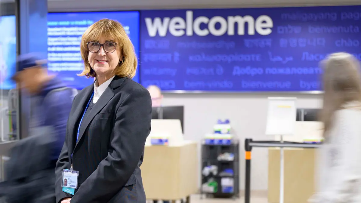 Guest Services Representative Monika Krawczyk is seen smiling under a Welcome sign at Memorial Hospital.