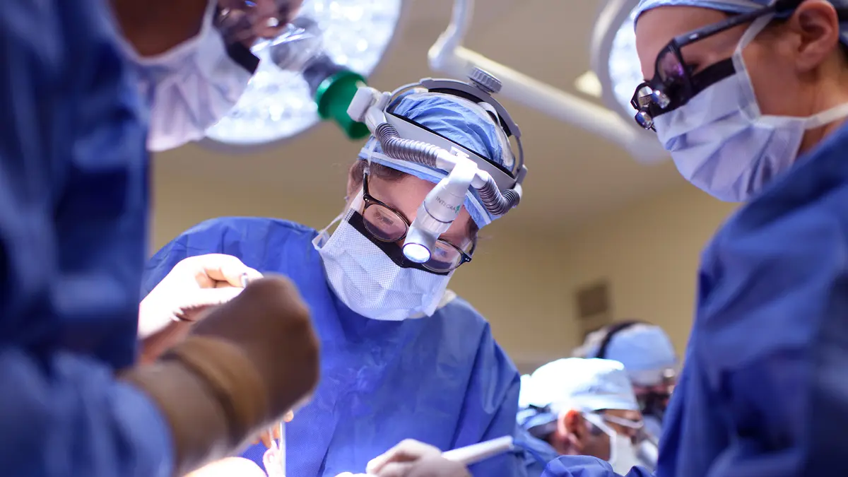 Head and neck surgeon Dr. Jennifer R. Cracchiolo, with 2 other surgeons, during surgery to rebuild a patient’s jaw. 