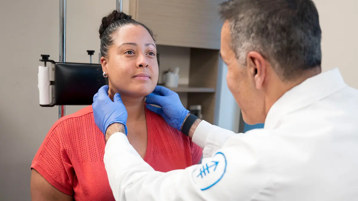 Head and neck surgeon Dr. Babak Givi uses his gloved hands to examine the throat of his MSK patient.    