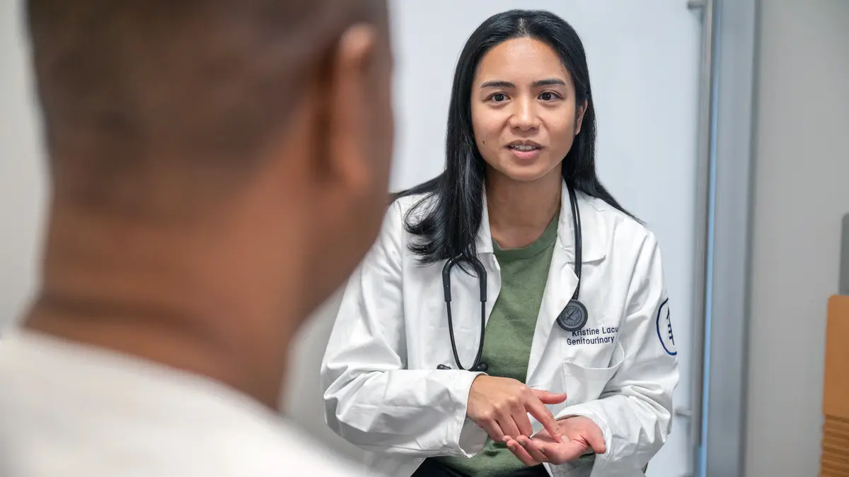 Dr. Peregrino Lacuna talks with her patient in an exam room at MSK Monmouth, where she treats people with prostate cancer. 