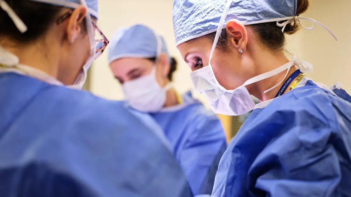Three MSK plastic surgeons during a procedure. 
