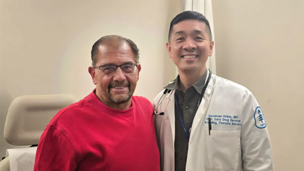 Anthony Valente, who enrolled in a clinical trial for zidesamtinib, is standing next to Dr. Alexander Drilon. 