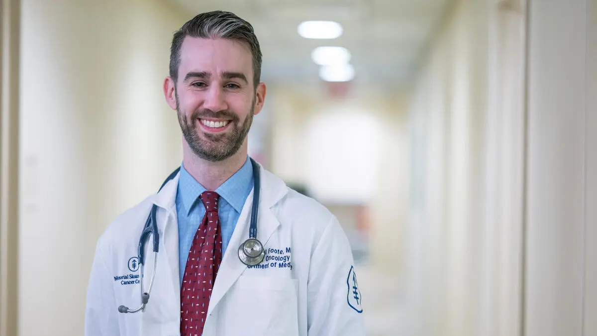 MSK medical oncologist Michael Foote, MD, is seen smiling in a hallway. 