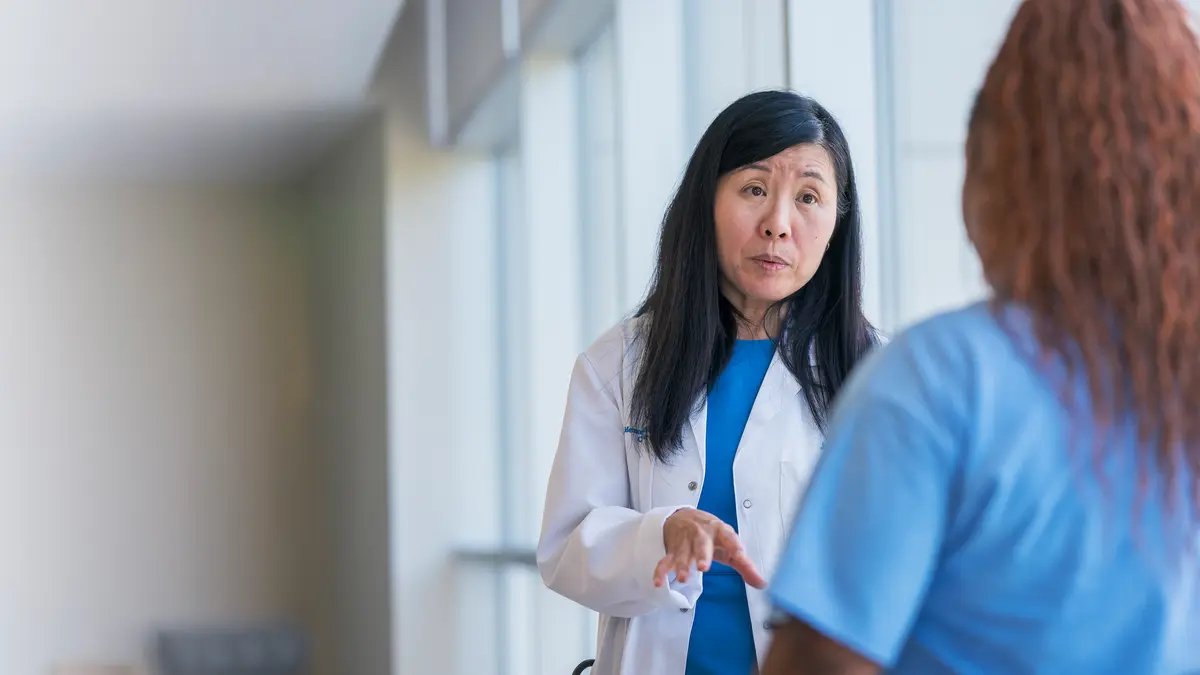 An MSK doctor speaks with a colleague in a hallway.