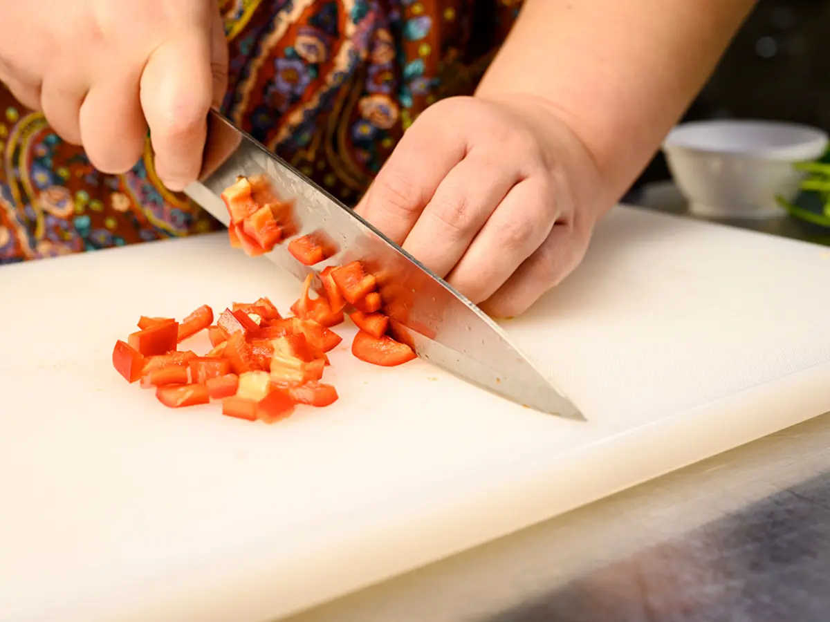 A person chopping food on a cutting board