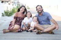 Family of four posing on the boardwalk at the beach