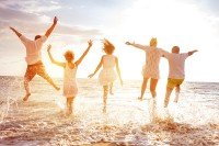 Five people on the beach during a sunset