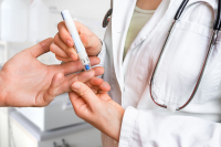 Doctor pricks finger of patient with diabetes